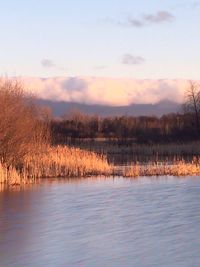 Scenic view of lake against sky at sunset