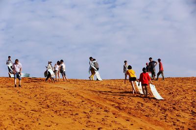 People on desert against sky