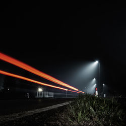 Light trails on train in city at night