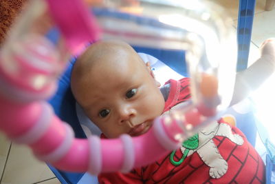 High angle view of cute baby boy looking away while lying in crib