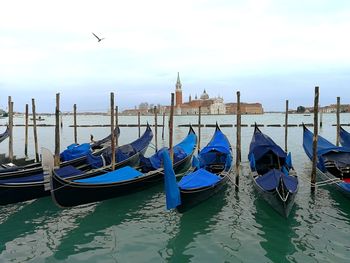 Boats moored in canal against sky