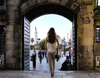 Rear view of woman walking in historic building 