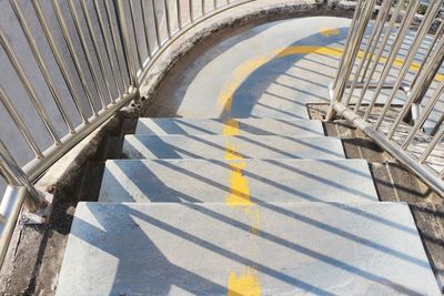 Concrete stairs of a footbridge with stainless steel handrails.