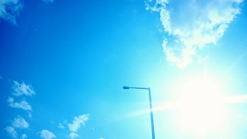 Low angle view of street light against blue sky