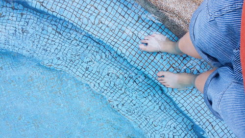 Low section of woman standing on poolside