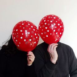 Close-up of hand holding red balloon