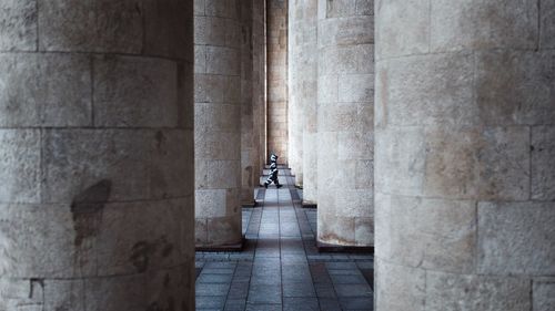 Side view of child walking amidst columns