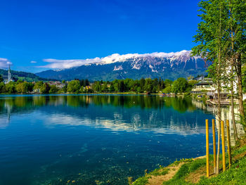 Scenic view of lake and mountains against blue sky