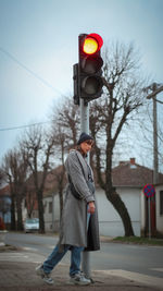 Full length of woman with streetlights walking on street