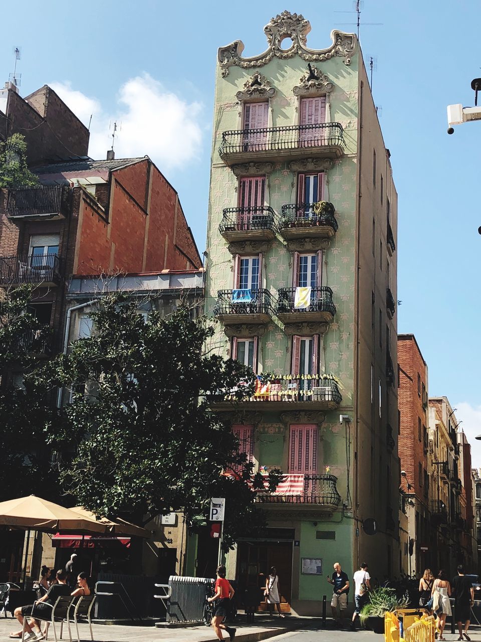 PEOPLE ON STREET BY BUILDINGS AGAINST SKY