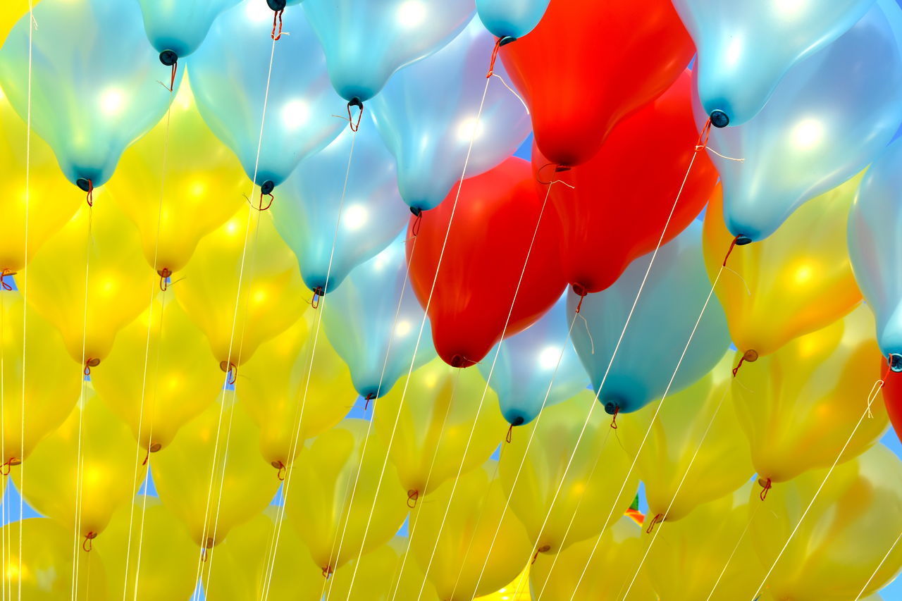 COLORFUL BALLOONS FLYING AGAINST BLUE SKY