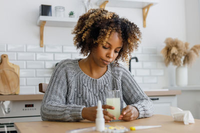 Portrait of young woman sitting on table