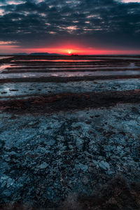 Scenic view of sea against dramatic sky during sunset