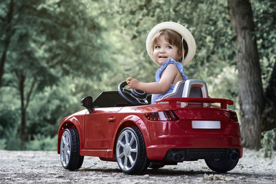 A girl riding a toy car