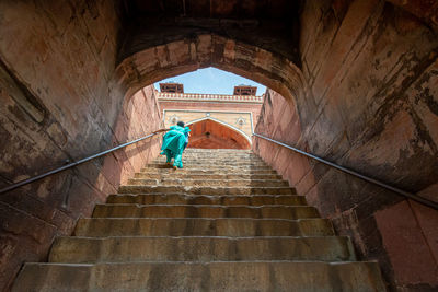 Low angle view of people walking on staircase of building