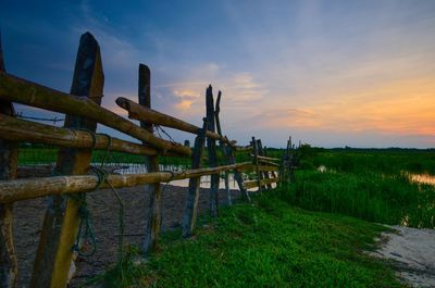 Built structure on field against sky during sunset