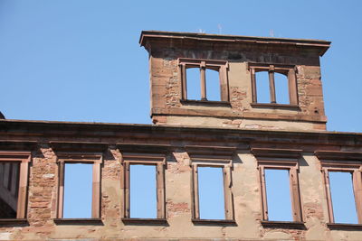 Low angle view of old building against clear blue sky