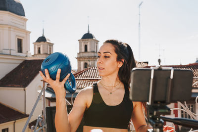 Young sporty fit woman coach doing online lessons through video call on her mobile phone