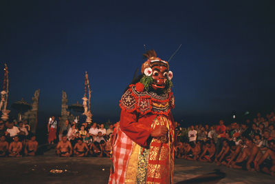 Group of people in traditional clothing against sky