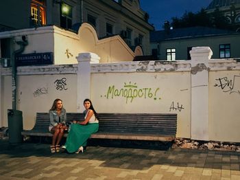 Woman sitting on wall with text