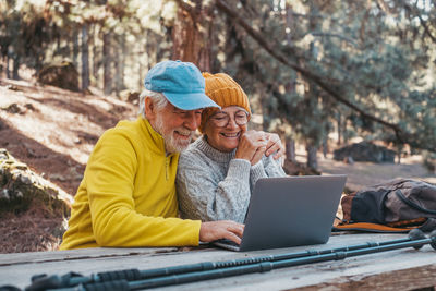 Portrait of woman using laptop while sitting on field