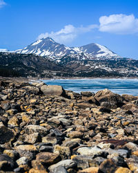 Scenic view of sea and snowcapped mountains against sky