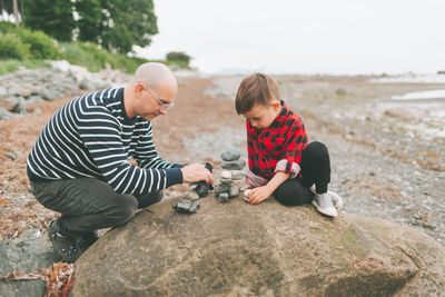 Father and son playing with rocks outdoors