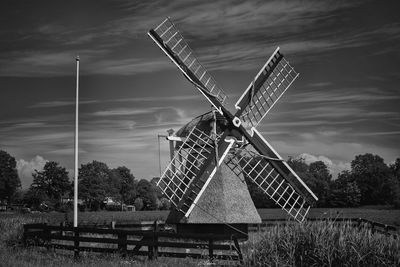 Traditional windmill on field against sky