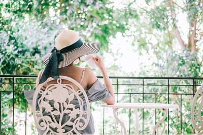 Midsection of woman holding umbrella against trees