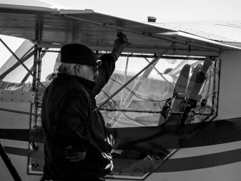 Side view of man standing by airplane