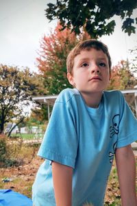 Close-up of boy looking away while leaning at park