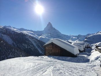 Snow covered landscape against blue sky