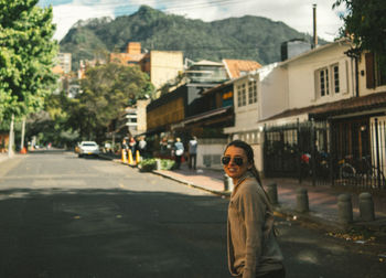 Man standing on road by city