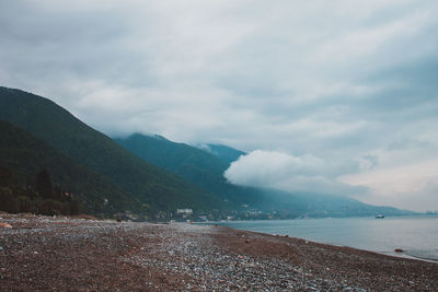 Scenic view of sea and mountains against sky