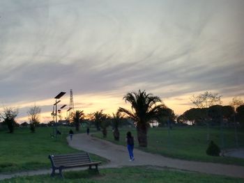 People in park against sky during sunset