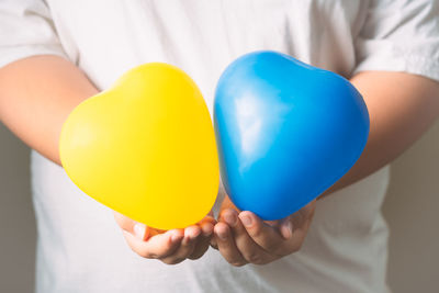 Midsection of man holding balloons