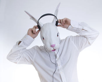 Man in bunny face wearing headphones against white background