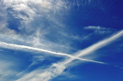 Low angle view of vapor trail in blue sky