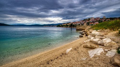 Scenic view of sea by buildings against sky