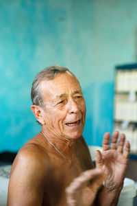 Shirtless happy man looking away while standing at home