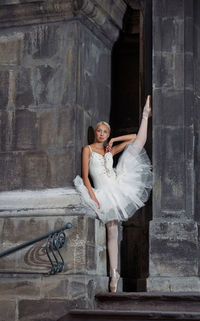 Full length of woman standing against wall