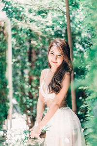 Portrait of beautiful woman against trees