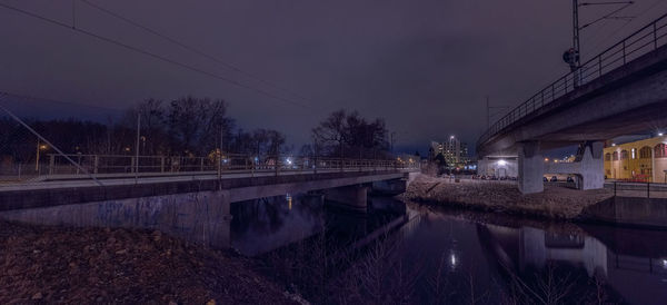 Illuminated canal amidst buildings against sky at night