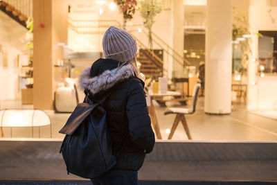 Teenage girl carrying backpack while standing in city