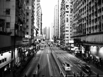 People on road amidst buildings in city