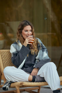 Young woman using mobile phone while sitting on sofa at home