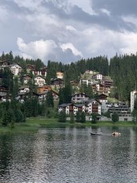 Scenic view of lake by buildings against sky