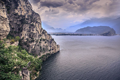 Scenic view of sea by mountains against sky