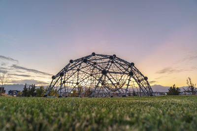 Built structure on field against sky during sunset