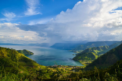 Scenic view of sea and mountains against sky